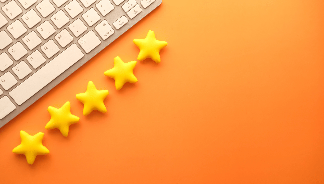 Five yellow star shapes lined up diagonally next to a keyboard on an orange background